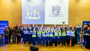 Uczniowie ze zwycięskich szkół prezentujący się grupowo na scenie.