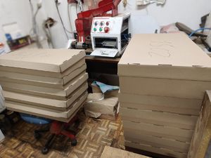 Tekturowe pudełka i maszyna do produkcji papierosów.