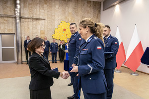 Komendant przypina medal i gratuluje pracownikowi cywilnemu.