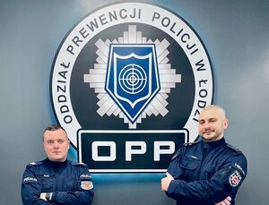 Dwaj policjanci stoją na ściance.
