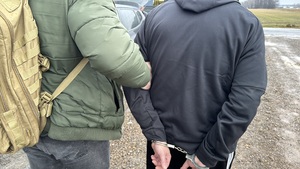 Policjant prowadzi zatrzymanego.