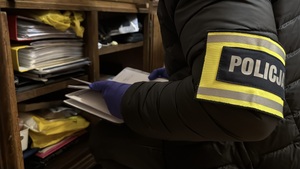 Policjant prowadzi przeszukanie.