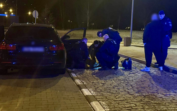 Policjanci udzielają pomocy leżącemu mężczyźnie