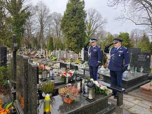 Nadinspektor Arkadiusz Sylwestrzak i podinspektor Tomasz Borowiecki oddają cześć zmarłym na cmentarzu.