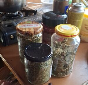 Słoiki na stolo, a w ich wnętrzu susz roślinny.