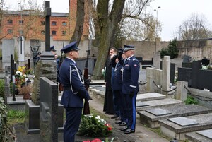 Goście w trakcie składania kwiatów na grobie.
