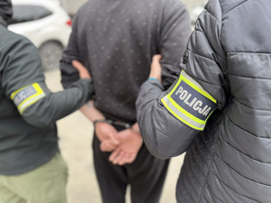Policjanci prowadzą zatrzymanego.