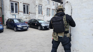 Policjant stoi przy ścianie.
