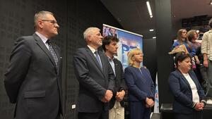 Zaproszeni goście stojący obok sceny.