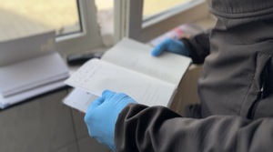 Policjant trzyma w ręku dokumenty.