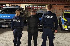 Policjanci prowadzą zatrzymanego.