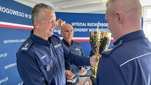 Zastępca Komendanta Wojewódzkiego Policji w Łodzi i Naczelnik Wydziału Ruchu Drogowego Komendy Wojewódzkiej Policji w Łodzi wręczają puchar.