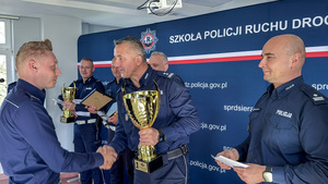 Zastępca Komendanta Wojewódzkiego Policji w Łodzi i Naczelnik Wydziału Ruchu Drogowego Komendy Wojewódzkiej Policji w Łodzi wręczają puchar.