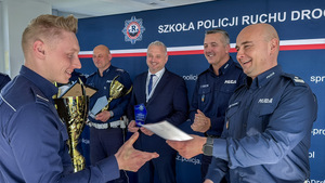 Zastępca Komendanta Wojewódzkiego Policji w Łodzi i Naczelnik Wydziału Ruchu Drogowego Komendy Wojewódzkiej Policji w Łodzi wręczają puchar.