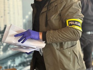 Policjant prowadzi przeszukanie.