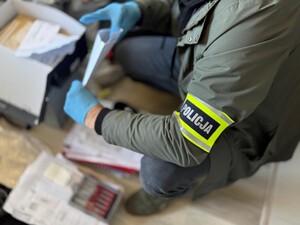 Policjant dokonuje przeszukania mieszkania.