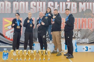 Policjanci na zdjęciu z ręczonymi medalami i pucharami.