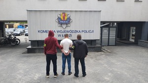 Policjanci trzymają zatrzymanego.