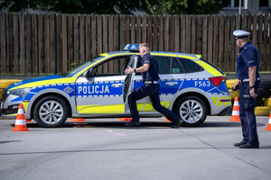 Policjant wsiada do radiowozu.