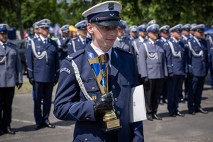 Policjant ruchu drogowego z pucharem w ręku.