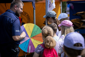 Dzieci z policjantami na profilaktycznych atrakcjach.