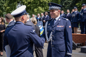 Komendant gratuluje policjantom, podaje rękę.