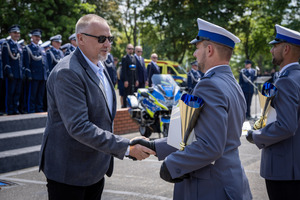 Mężczyzna gratuluje policjantowi.