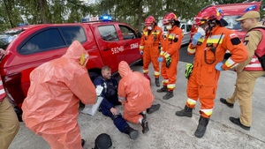 Pojazdy służbowe oraz mundurowani funkcjonariusze Policji i Straży Pożarnej podczas ćwiczeń.
