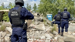 Umundurowani funkcjonariusze Policji stojący z bronią w reku.