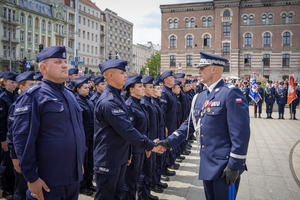 Umundurowani funkcjonariusze Policji uściskujący dłonie.