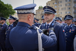 Umundurowani funkcjonariusze otrzymujący awanse podczas uroczyści.