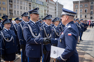 Umundurowani funkcjonariusze otrzymujący awanse podczas uroczyści.