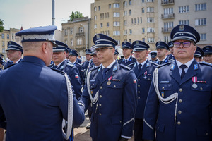 Umundurowani funkcjonariusze otrzymujący awanse podczas uroczyści.