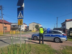 Policjanci i radiowóz w okolicy szkoły, lustracja oznakowania.