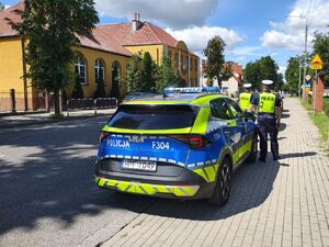 Policjanci i radiowóz w okolicy szkoły, lustracja oznakowania.