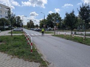Policjant na przejściu dla pieszych sprawdza oznakowanie poziome.
