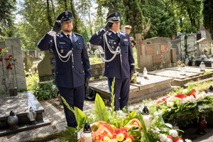 Umundurowani funkcjonariusze Policji oddający honor przy grobie.