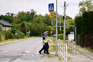 Policjanci przechodzą przez przejście dla pieszych.