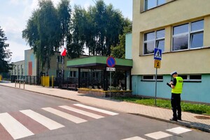 Policjant stoi przy przejściu dla pieszych.