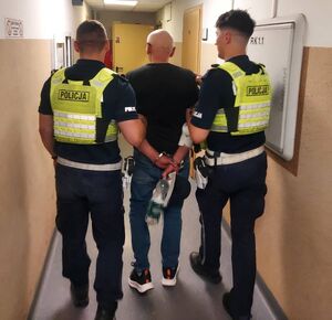 Policjanci prowadza zatrzymanego.