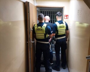 Policjanci prowadza zatrzymanego.