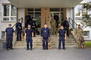 Policjanci, grupowe zdjęcie na schodach przewodników psów wraz z policjantami.