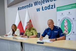 Policjant, Komendant Straży Granicznej nauczyciel szkoły mundurowej popisują porozumienie, obok flagi Polski.