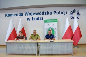 Policjant, Komendant Straży Granicznej nauczyciel szkoły mundurowej popisują porozumienie, obok flagi Polski.