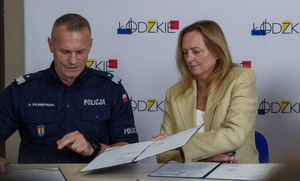 Umundurowany Policjant i Marszałek Województwa Łódzkiego na wspólny zdjęciu.