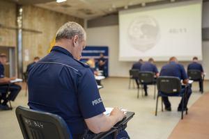 Umundurowani funkcjonariusze policji podczas rozwiązywania test podczas konkursu.
