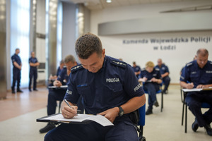 Umundurowani funkcjonariusze policji podczas rozwiązywania test podczas konkursu.