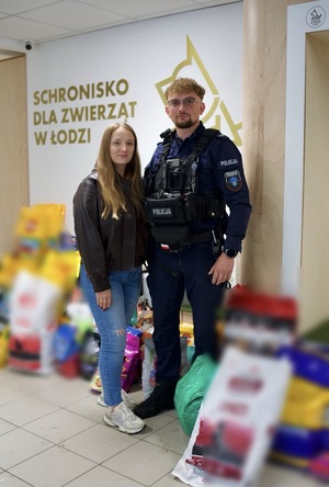 Umundurowany Funkcjonariusz Policji z żoną przekazujący karmę dla Schroniska dla Zwierząt w Łodzi.