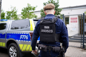 Umundurowany funkcjonariusz Policji z żoną na spacerze z podopiecznymi schroniska.