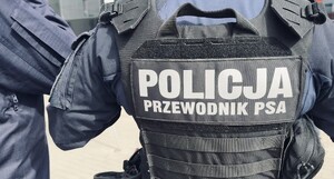 Policjant umundurowany w kamizelce z napisem przewodnik psa.